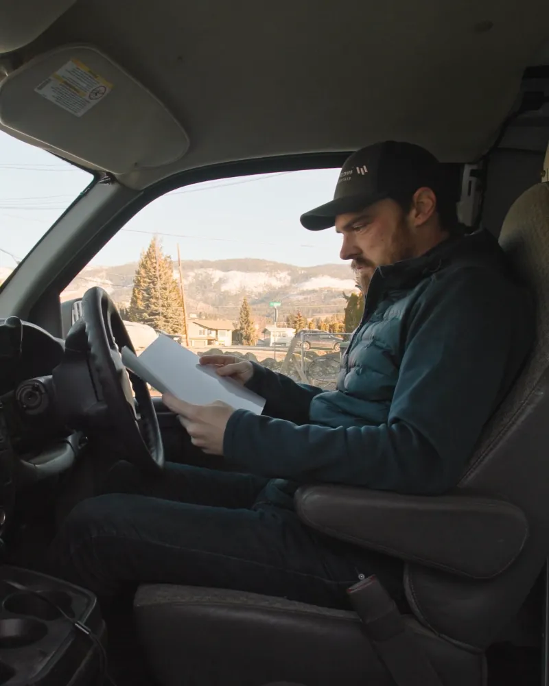 Electrician sitting in his van doing paperwork.